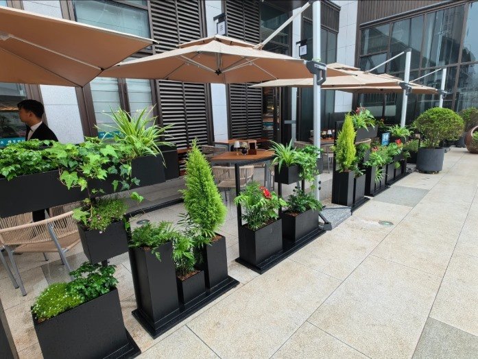 Black commercial planters outside a modern commercial building